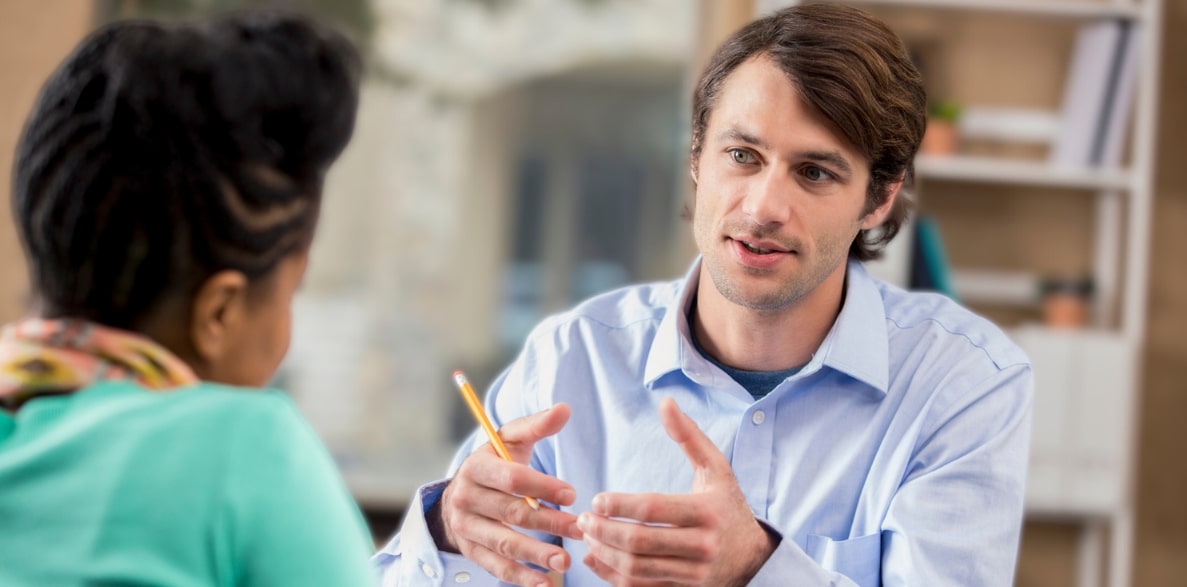 Two colleagues engaged in conversation while seated at a table