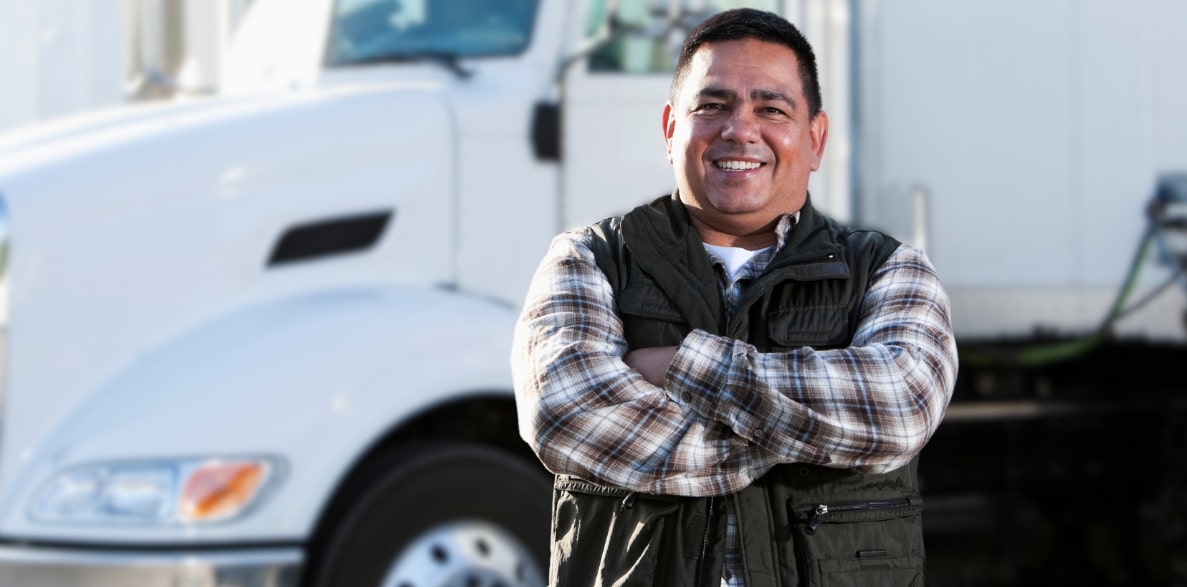 A man standing in front of a semi truck