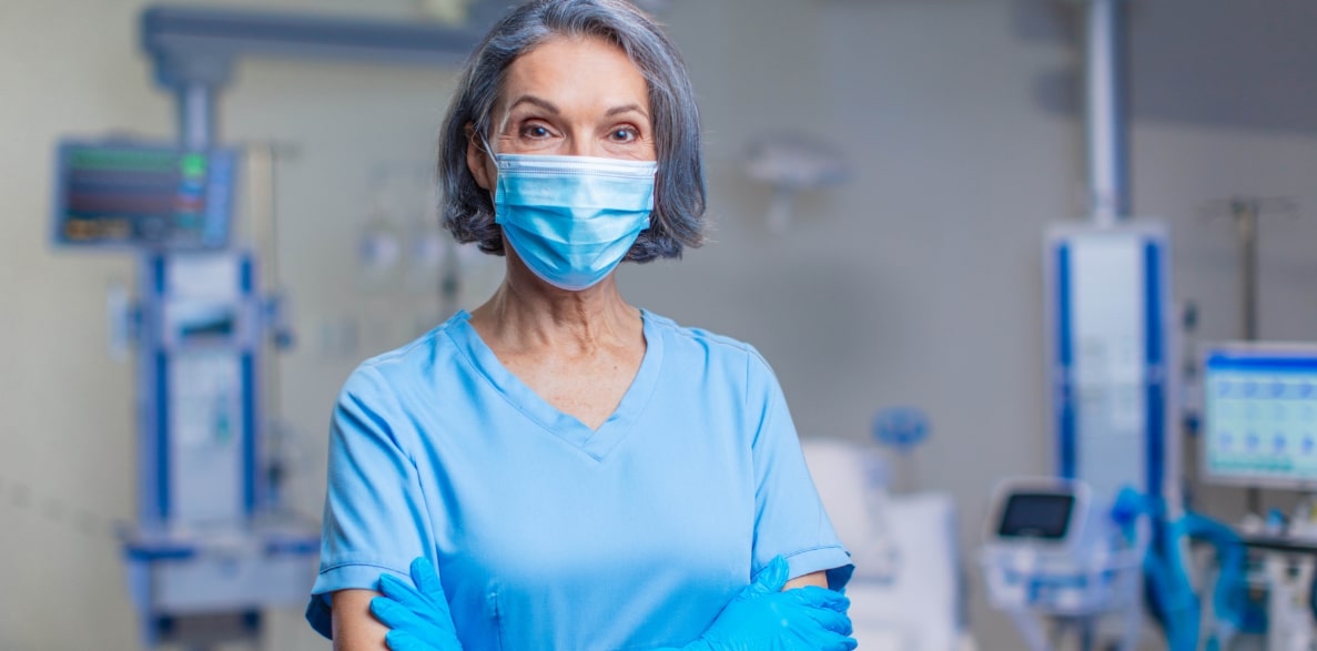 A healthcare professional wearing scrubs and a mask