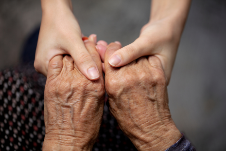 Two peoples hands - one person holding the other with both hands