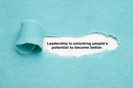 Paper ripped to reveal "Leadership is unlocking people's potential to become better."