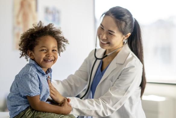 Female doctor with stethoscope on young boy