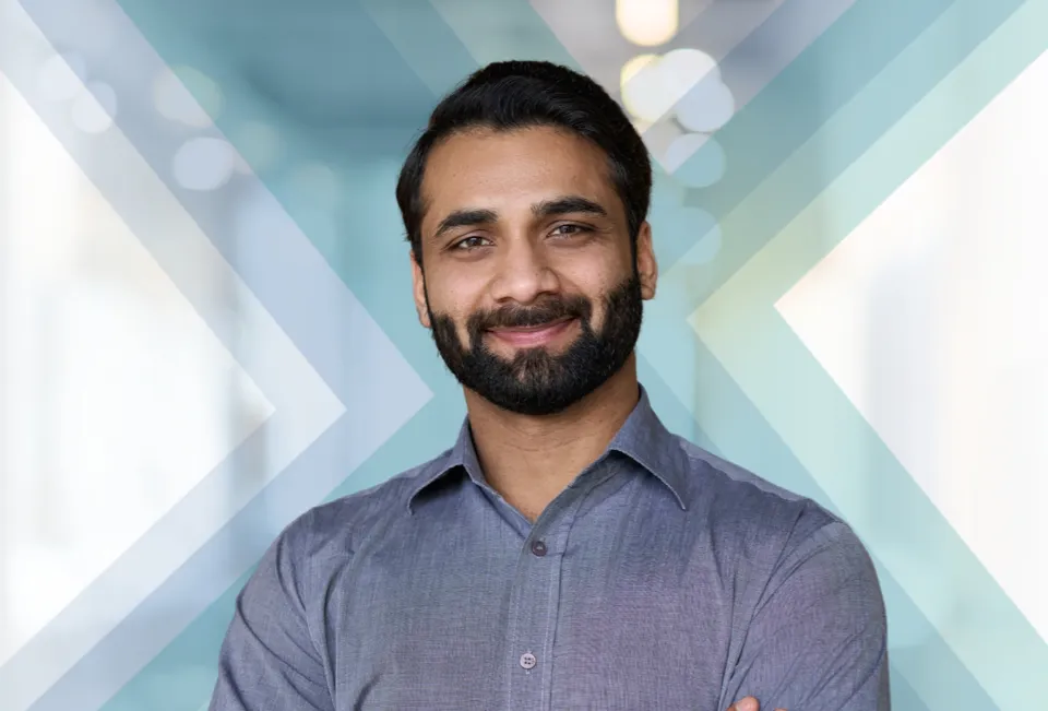 Man with beard smiling at camera from the chest up with the Baxter X transparent in the background