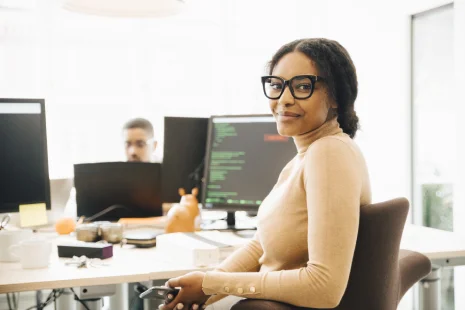 Employee at desk smiling at camera