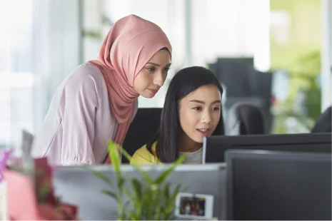 Two women looking at computer screen