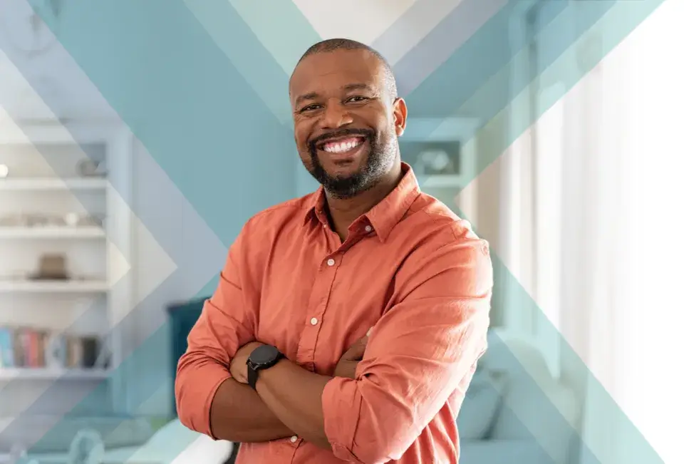 A smiling man with a beard, wearing an orange shirt