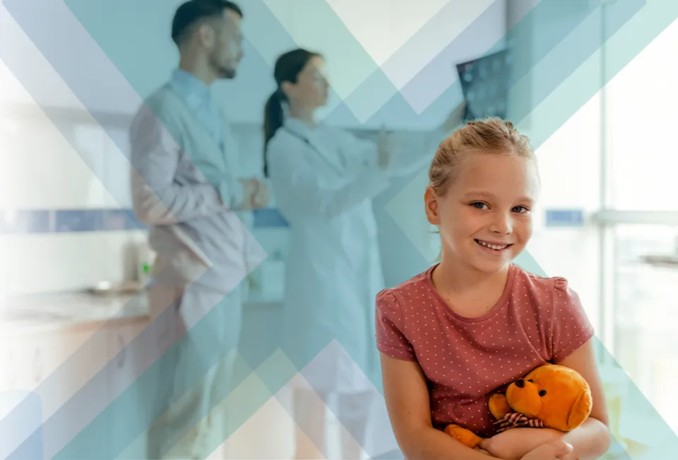 Little girl holding a teddy bear at the doctor's office 