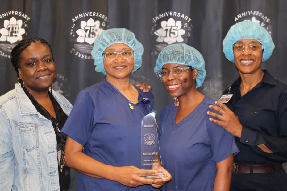4 women employees holding an award