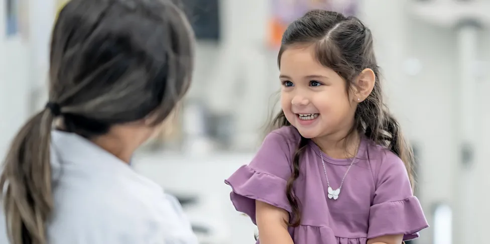 A doctor seating with a little girl