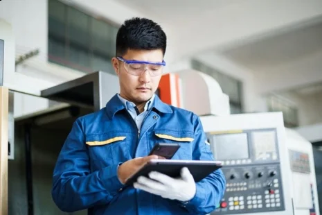 Male employee working with safety goggles and tablet