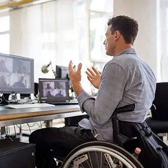 A man in a wheelchair at an office workstation