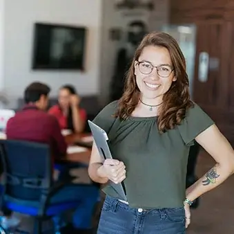 a smiling woman holding a laptop