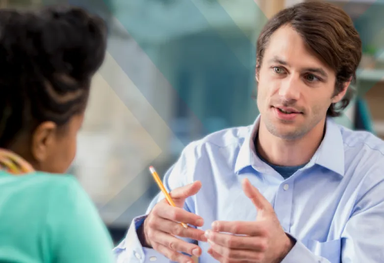 Two colleagues engaged in conversation while seated at a table