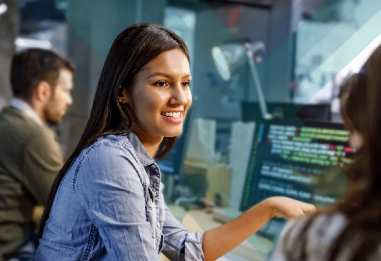 A woman smiling while focused on her computer screen