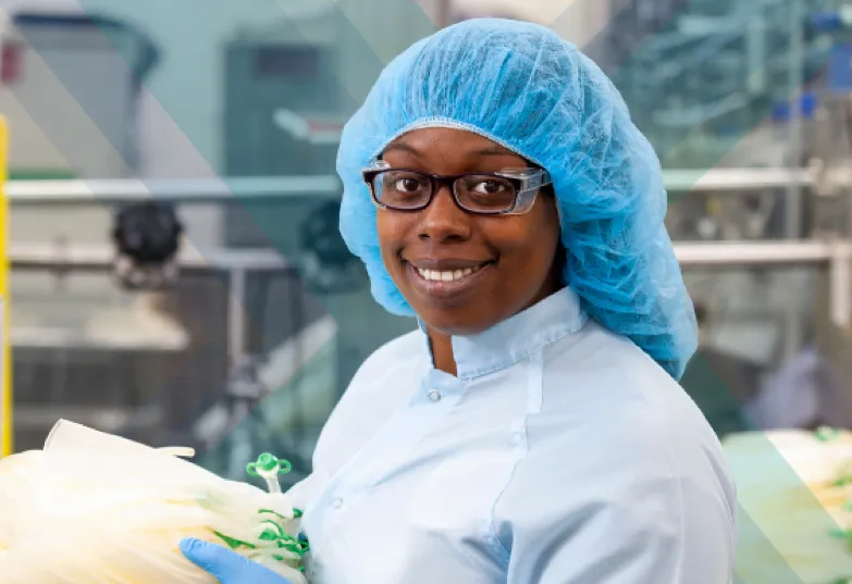 A smiling woman in manufacturing attire