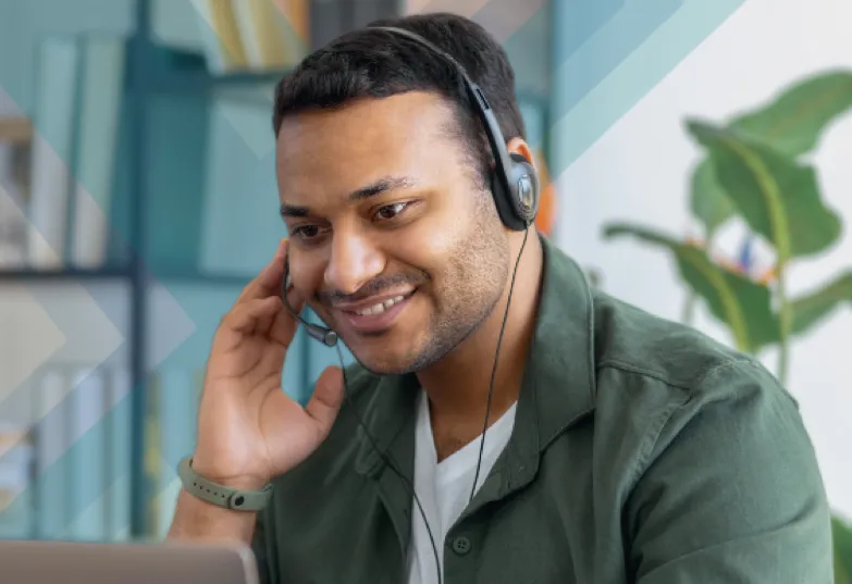 A man working on his laptop with a headset on