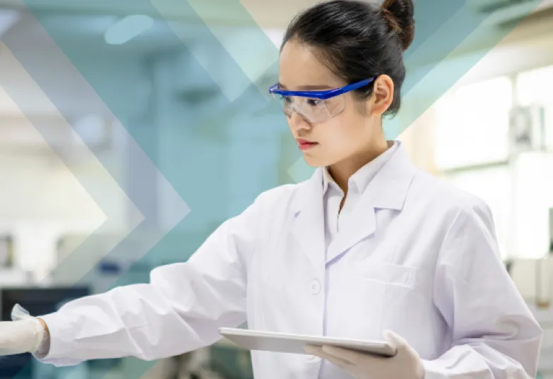 A woman in a lab coat and glasses holding a tablet