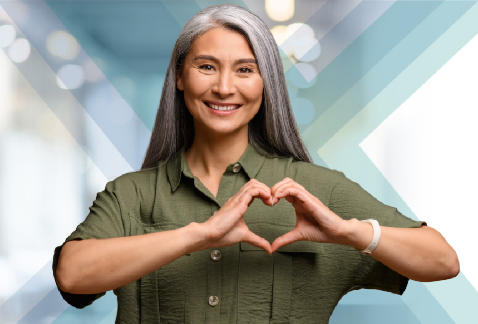 Woman smiling and forming a heart shape with her hands