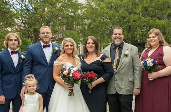Family photo at a wedding with the bridge holding a bouquet of flowers