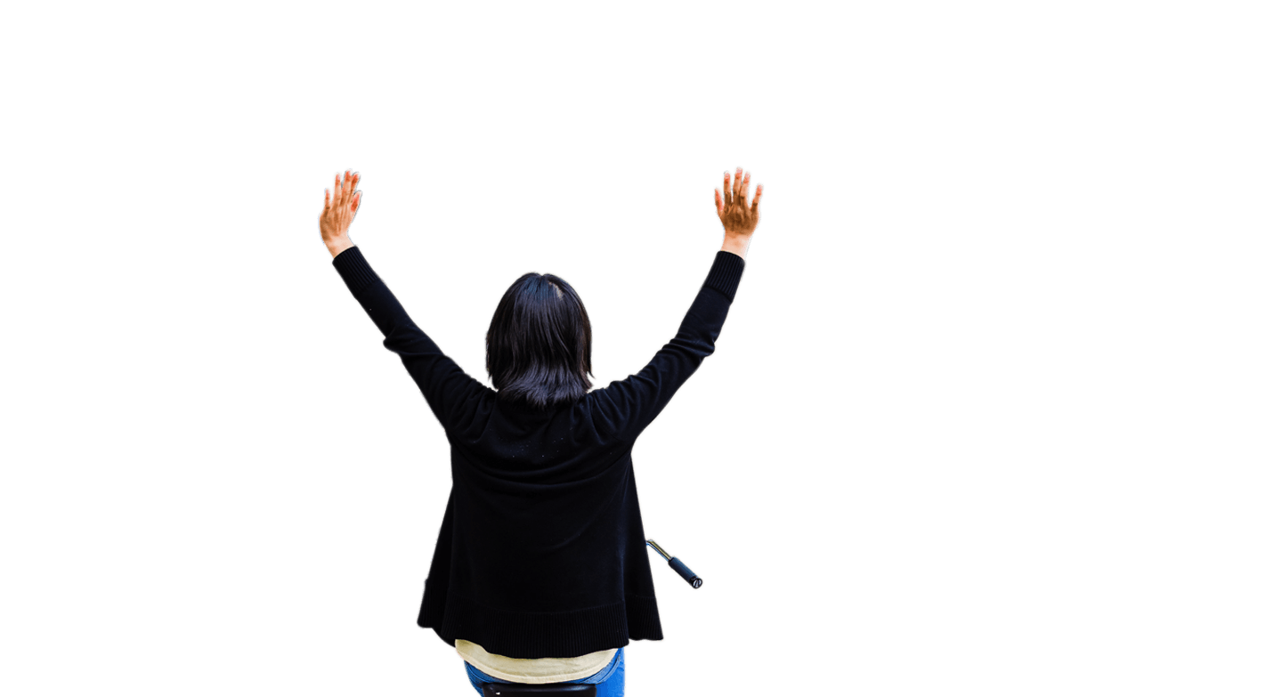 Woman on bike raises hands in air in celebration, during a busy lunch hour outside on VMware’s campus.