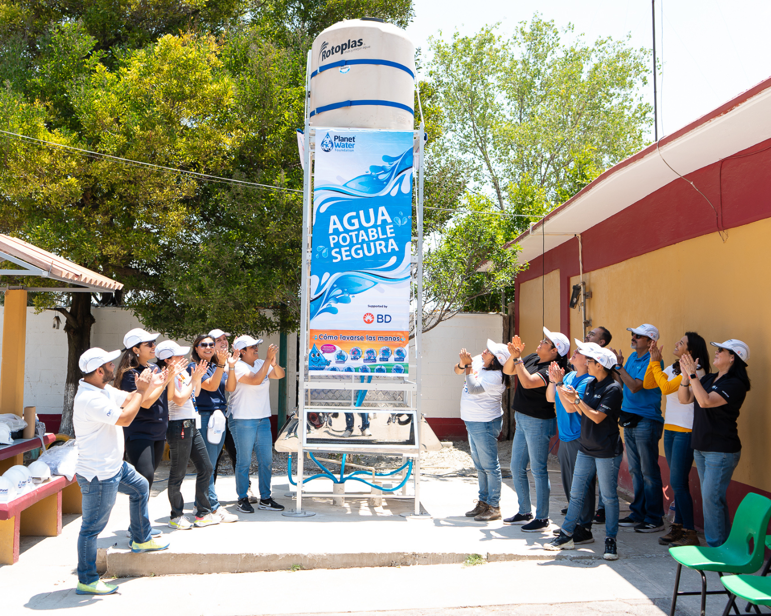 Volunteers gathered around a newly installed clean water system supported by BD and Planet Water Foundation, celebrating improved access to safe drinking water for the local community.
