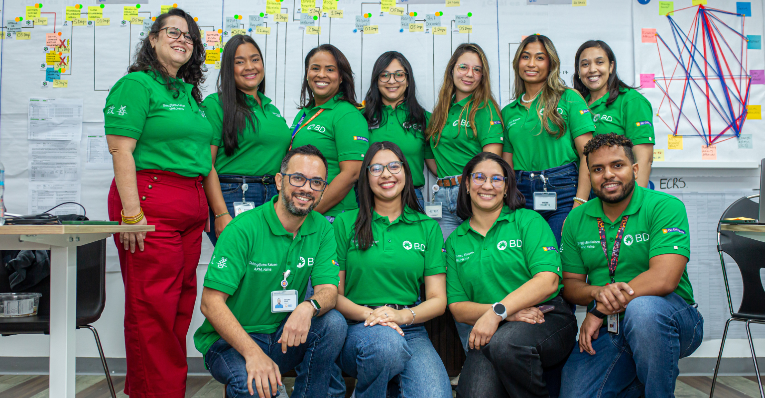 Group of BD associates wearing green BD shirts in a collaborative workspace.