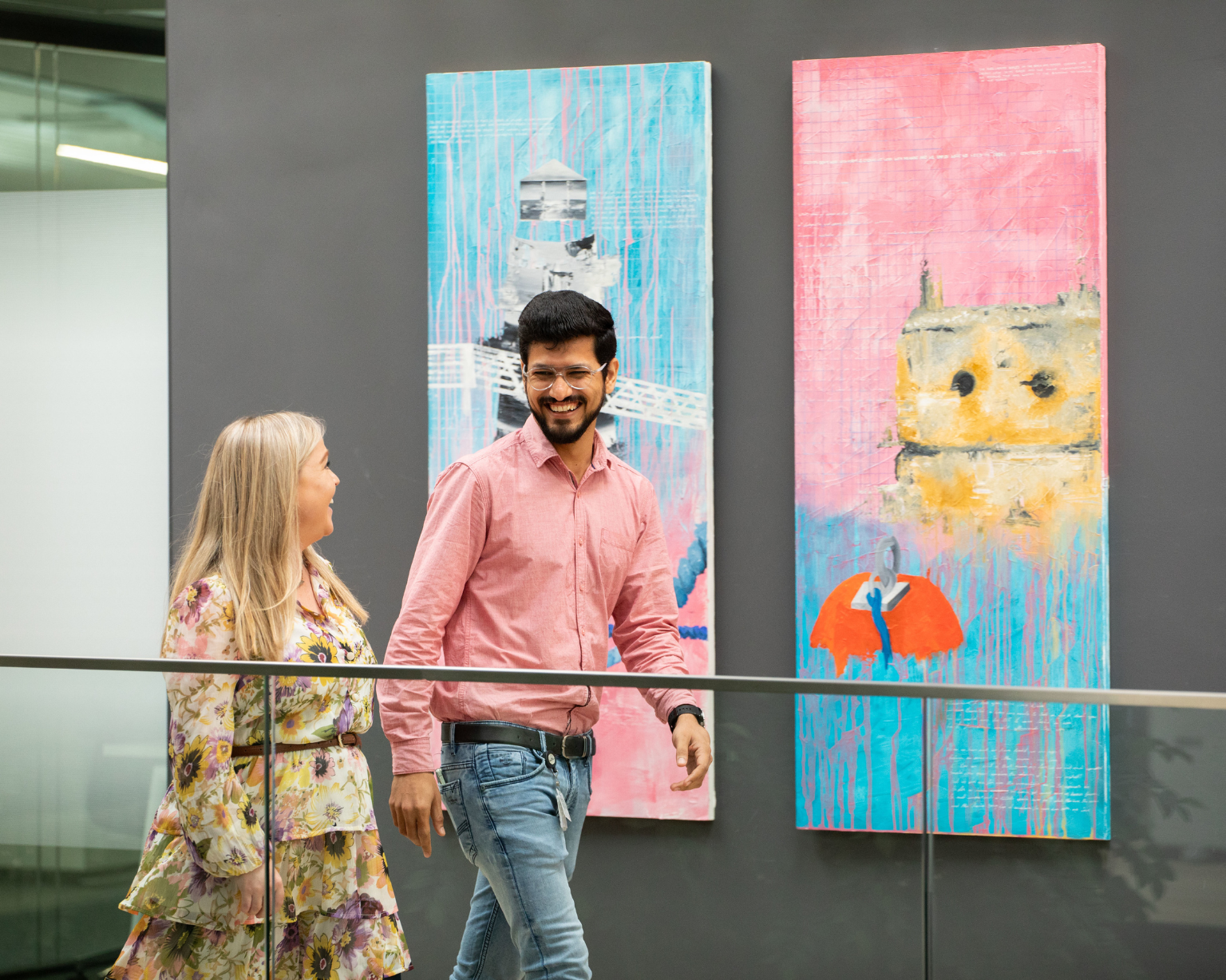 Dos BD associates caminando frente a una gran obra de arte abstracta en la oficina de BD en Limerick.