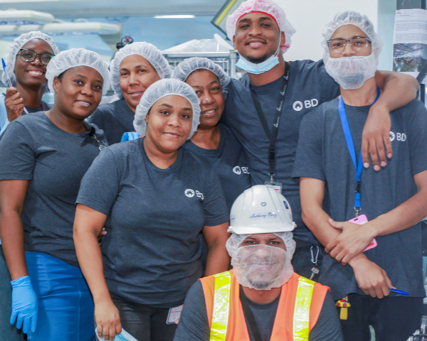 Un groupe de collaborateurs de BD, vêtus de chemises grises à l'effigie de BD, étaient rassemblés en un petit groupe. Certains portaient des charlottes.