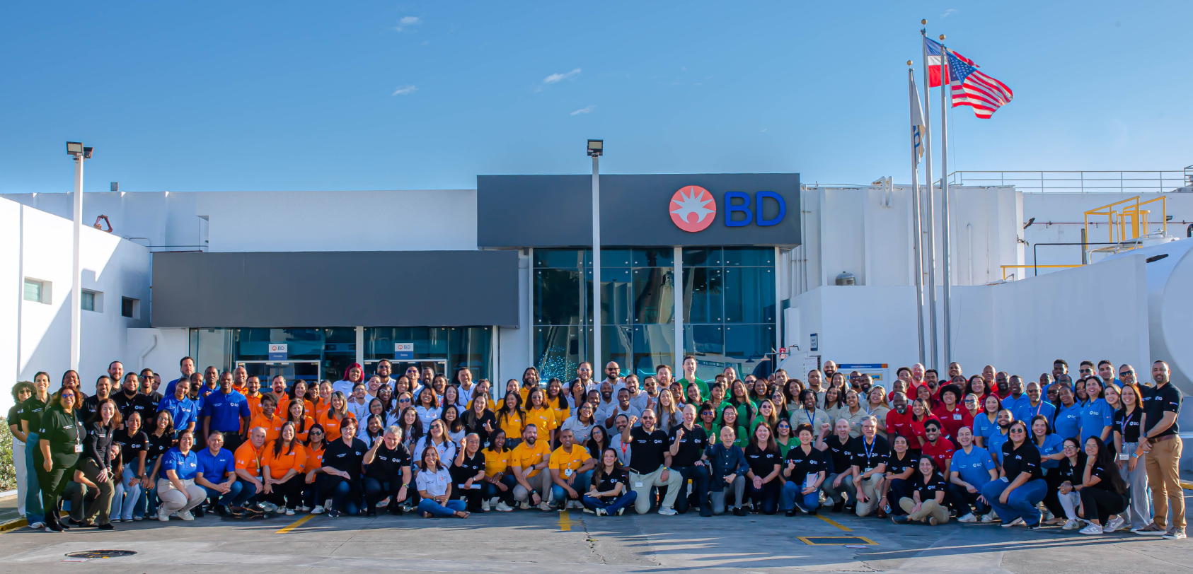 Grande grupo de associados da BD, vestindo camisas da BD, do lado de fora de uma unidade da BD na República Dominicana.
