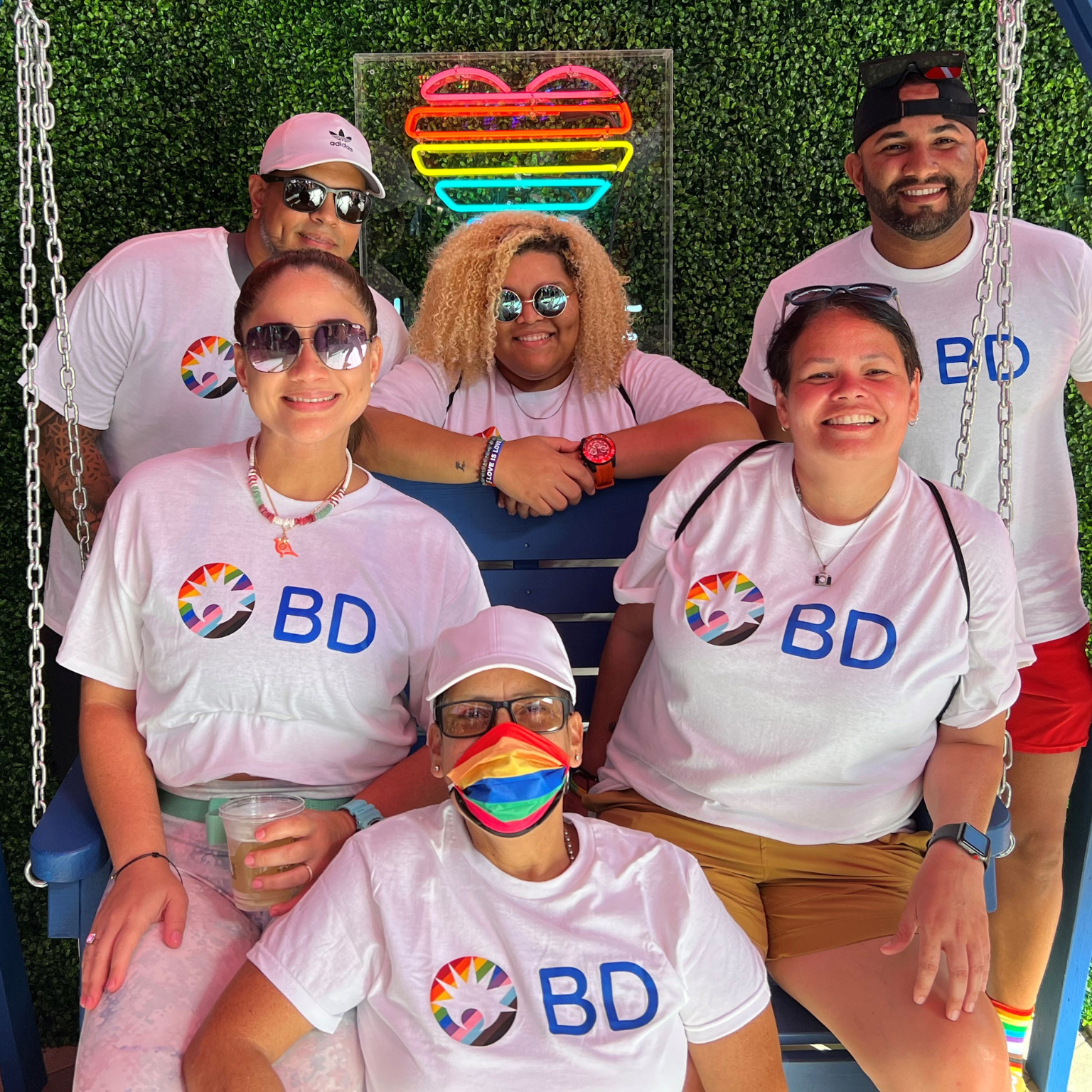 Seis associados da BD vestindo camisas com o logotipo do Mês do Orgulho BD.