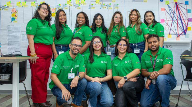 Um grande grupo de associados da BD vestindo camisas verdes da BD.