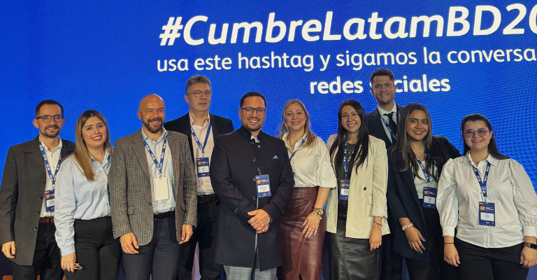 Grupo de asociados de BD de pie en el escenario durante un evento regional de liderazgo.