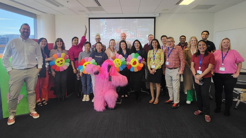 Large group of BD associates smiling at the camera at an event in a BD office