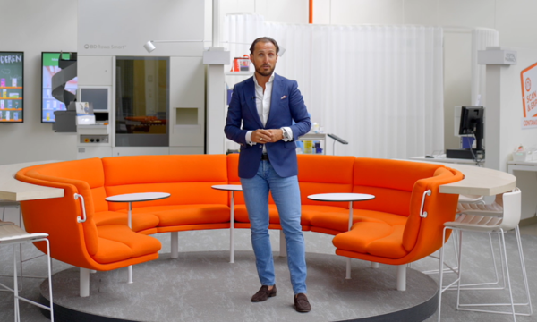 Alexander Alonso, Country General Manager, standing in a modern office space with circular seating