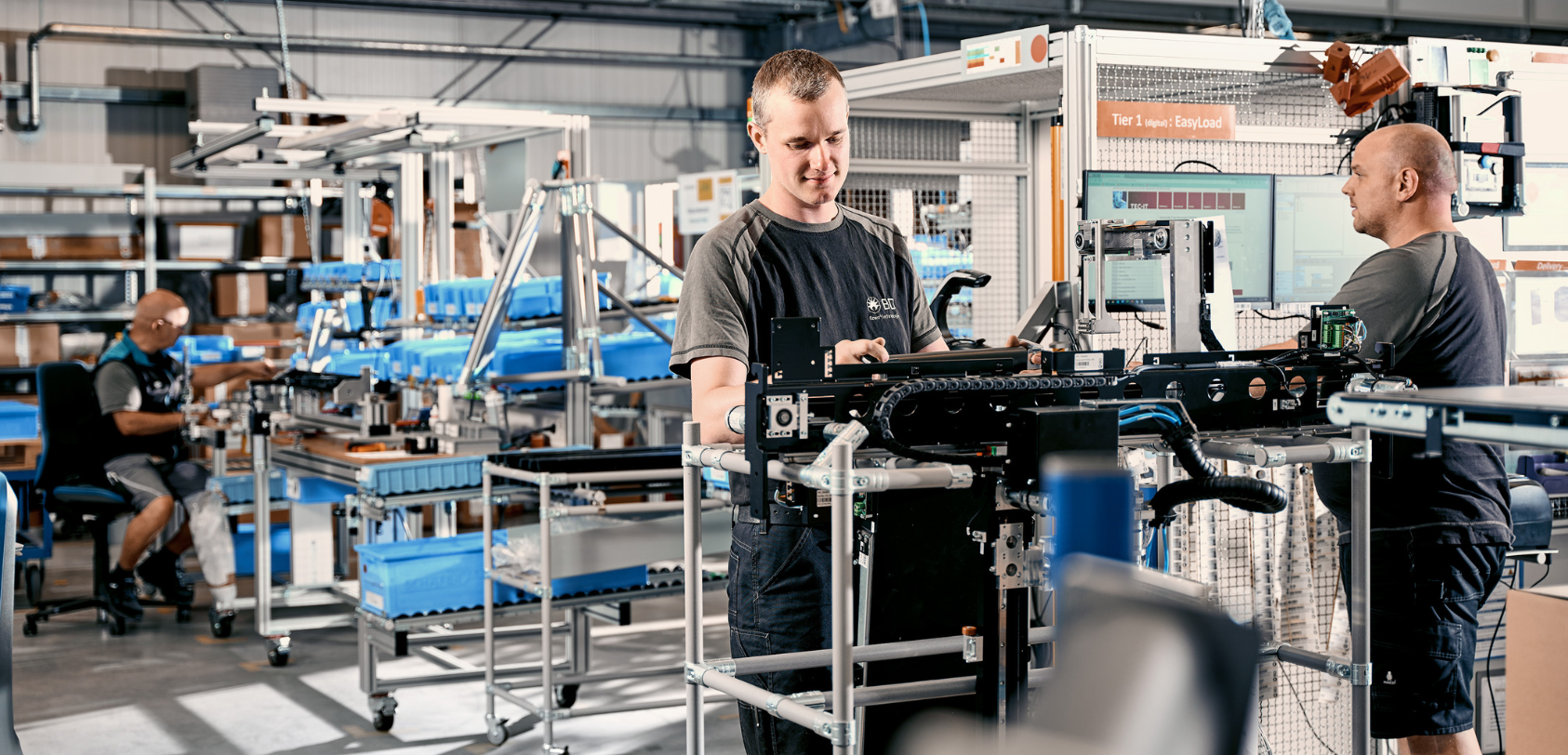 Große Gruppe von BD‑Mitarbeitenden, die sich in einem Innenraum mit kleinen Feierlichkeiten versammelt hat.