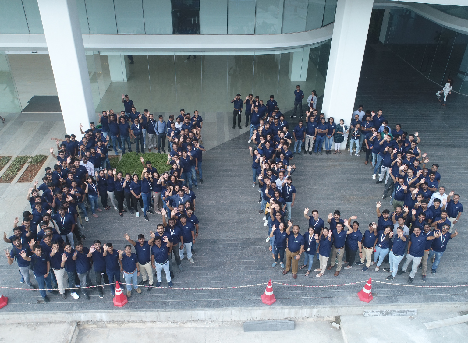 Large group of BD associates gathered outdoors, forming the letters “BD” in the way they are stood