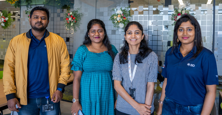 Four BD associates standing together inside a BD office