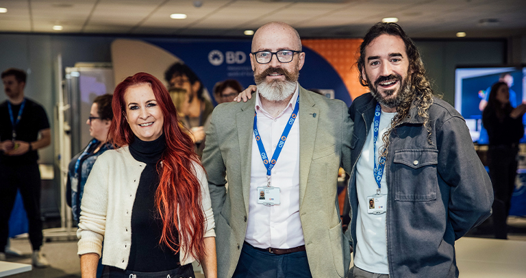 Three BD associates standing together at a BD‑branded event space.