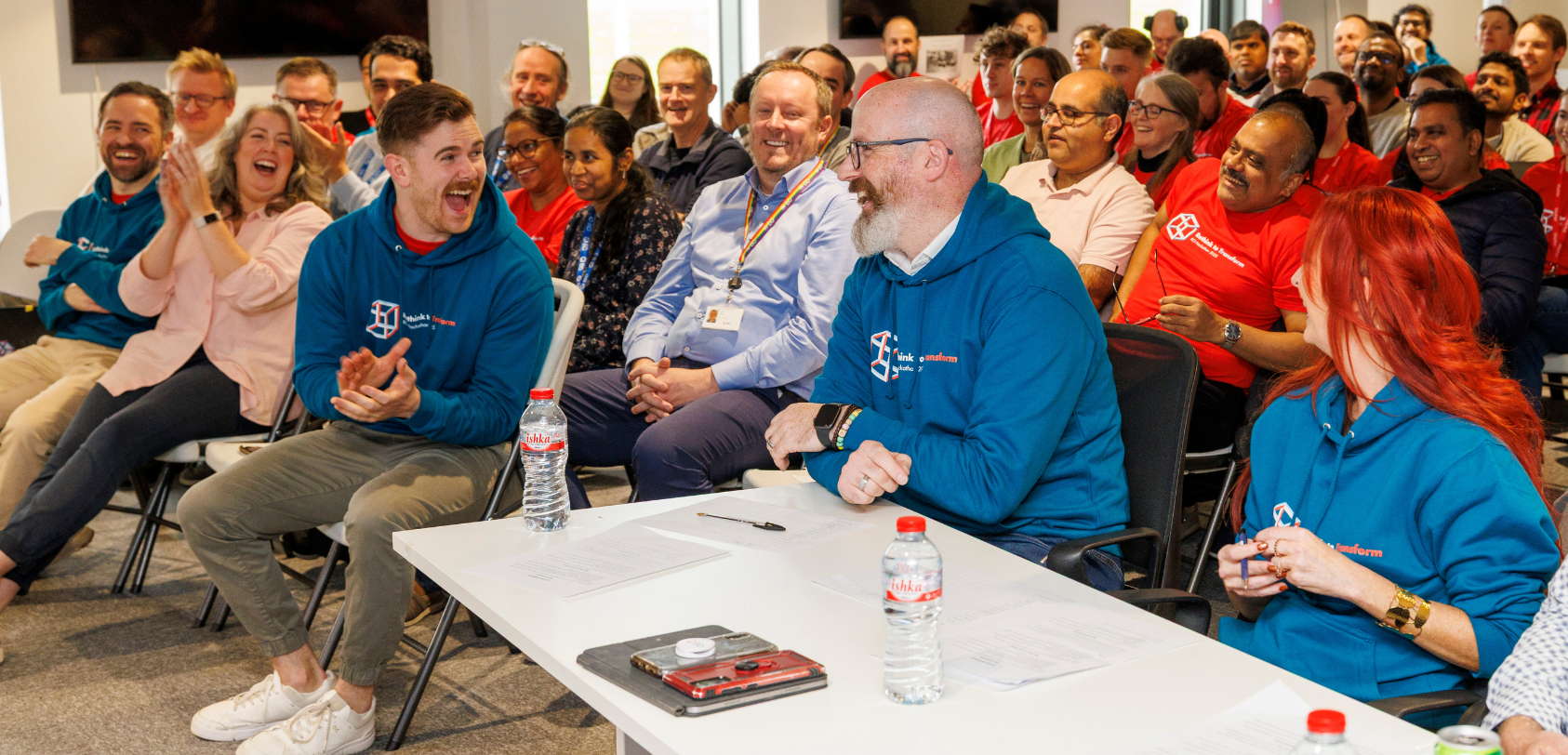 BD associates seated indoors laughing and engaging during a team event.