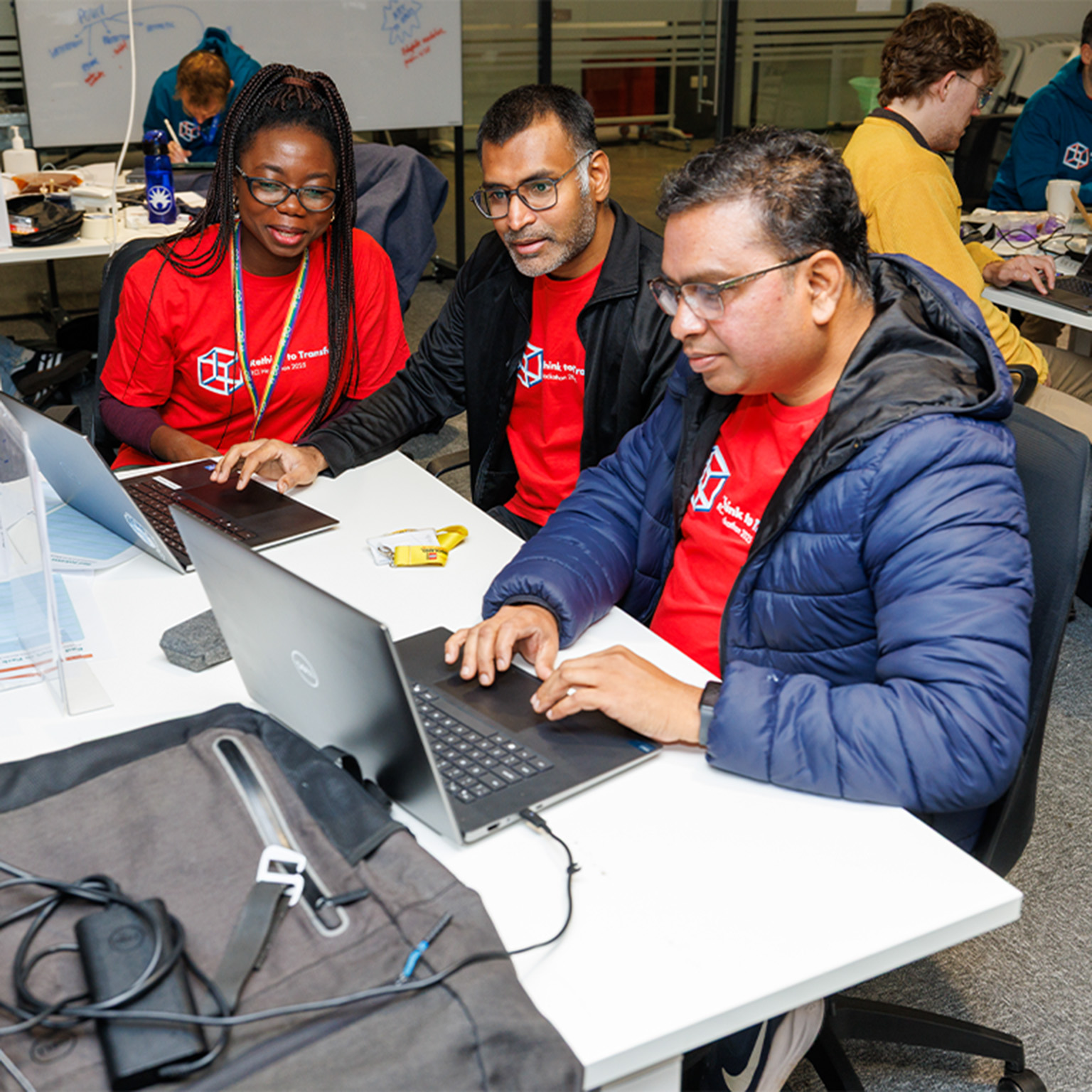 BD associates collaborating at desks using laptops during a team working session.