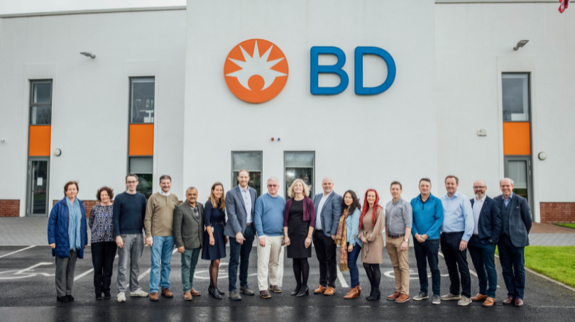 Group of BD associates standing together outside a BD building for a group photo.