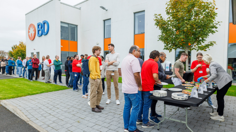 BD associates outdoors beside a BD building during an event.