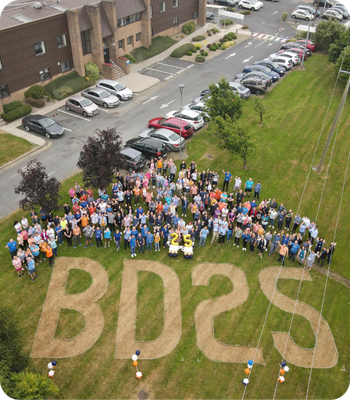 Aerial view of BD associates gathered outdoors forming &ldquo;BD25&rdquo; on grass.