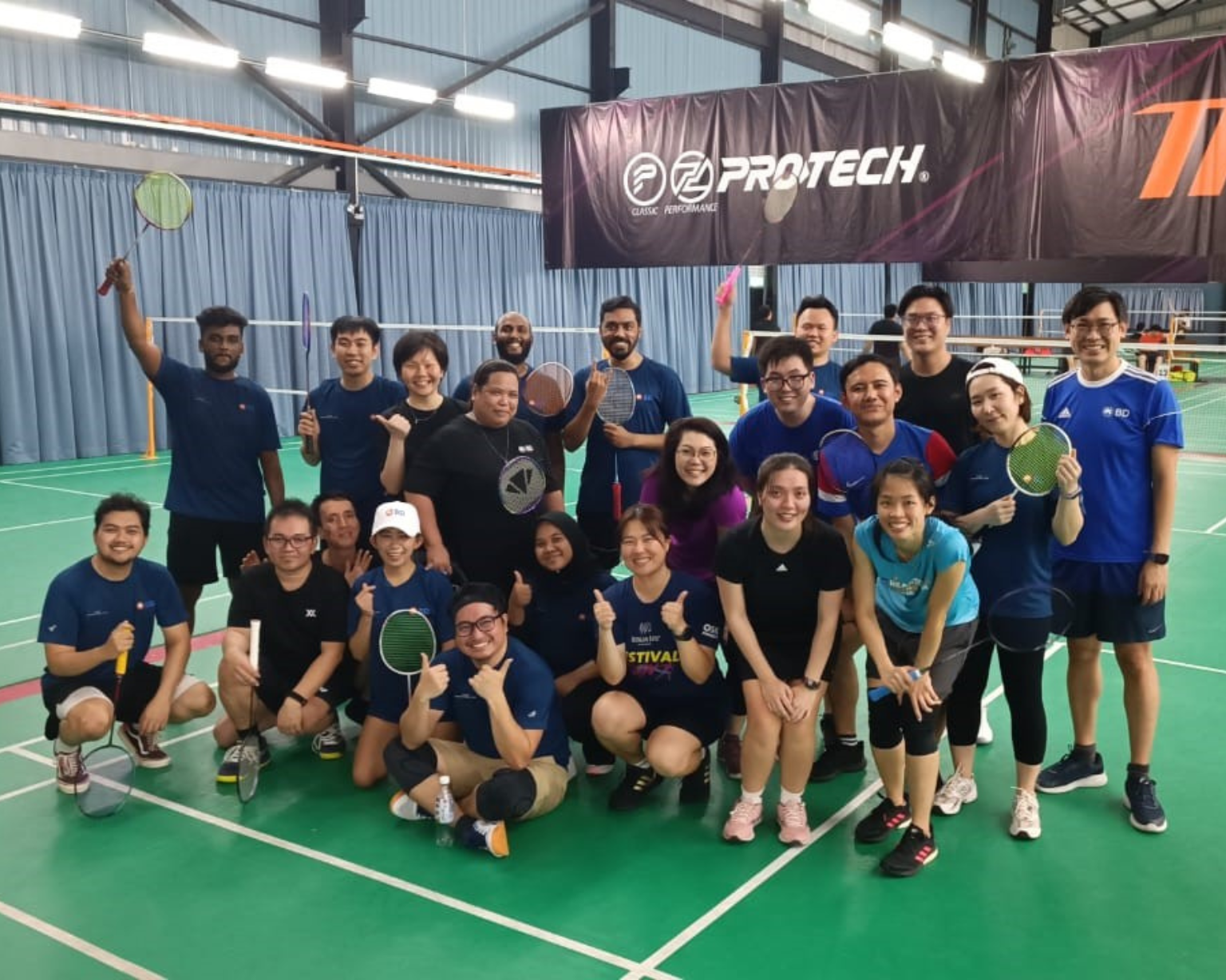 BD associates posing together on an indoor badminton court