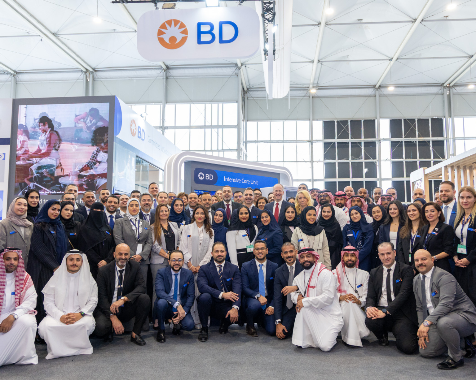 Large group of BD associates gathered at a BD‑branded exhibition stand.