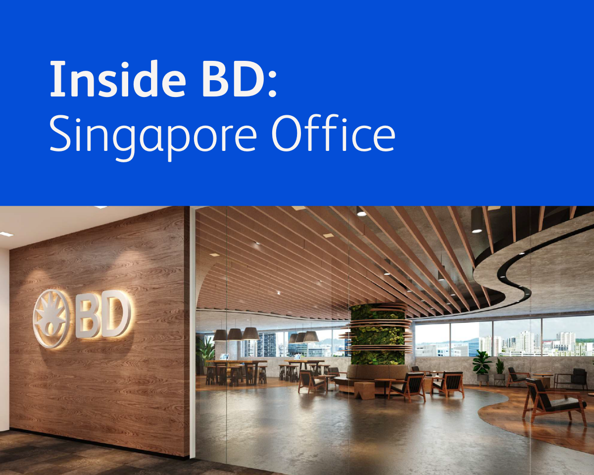 Graphic displaying the text ‘Inside BD: Singapore Office’ above a photograph of a modern BD office interior featuring wood-paneled walls, a large illuminated BD logo, curved ceiling slats, glass walls, and open seating areas.