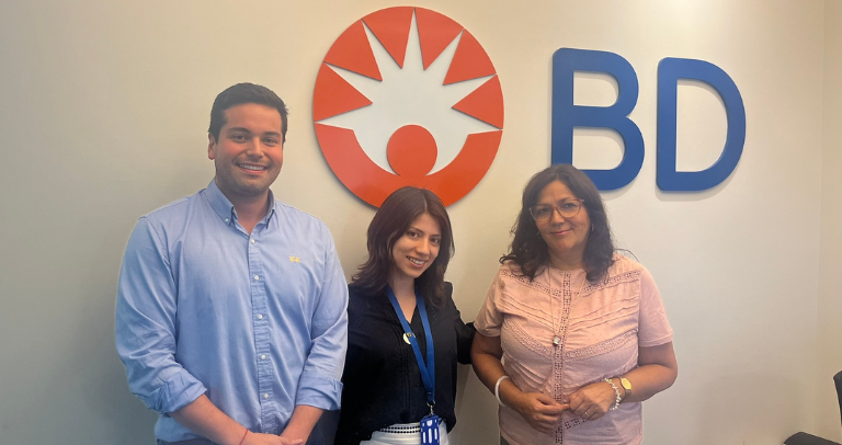 Three BD associates standing together in front of a BD logo inside an office.