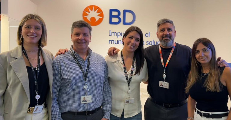 Group of BD associates standing together inside a meeting room.