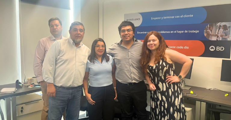 Group of BD associates standing together in an office workspace.