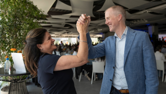 Dois associados da BD cumprimentando‑se com um &ldquo;high‑five&rdquo; em um evento interno.